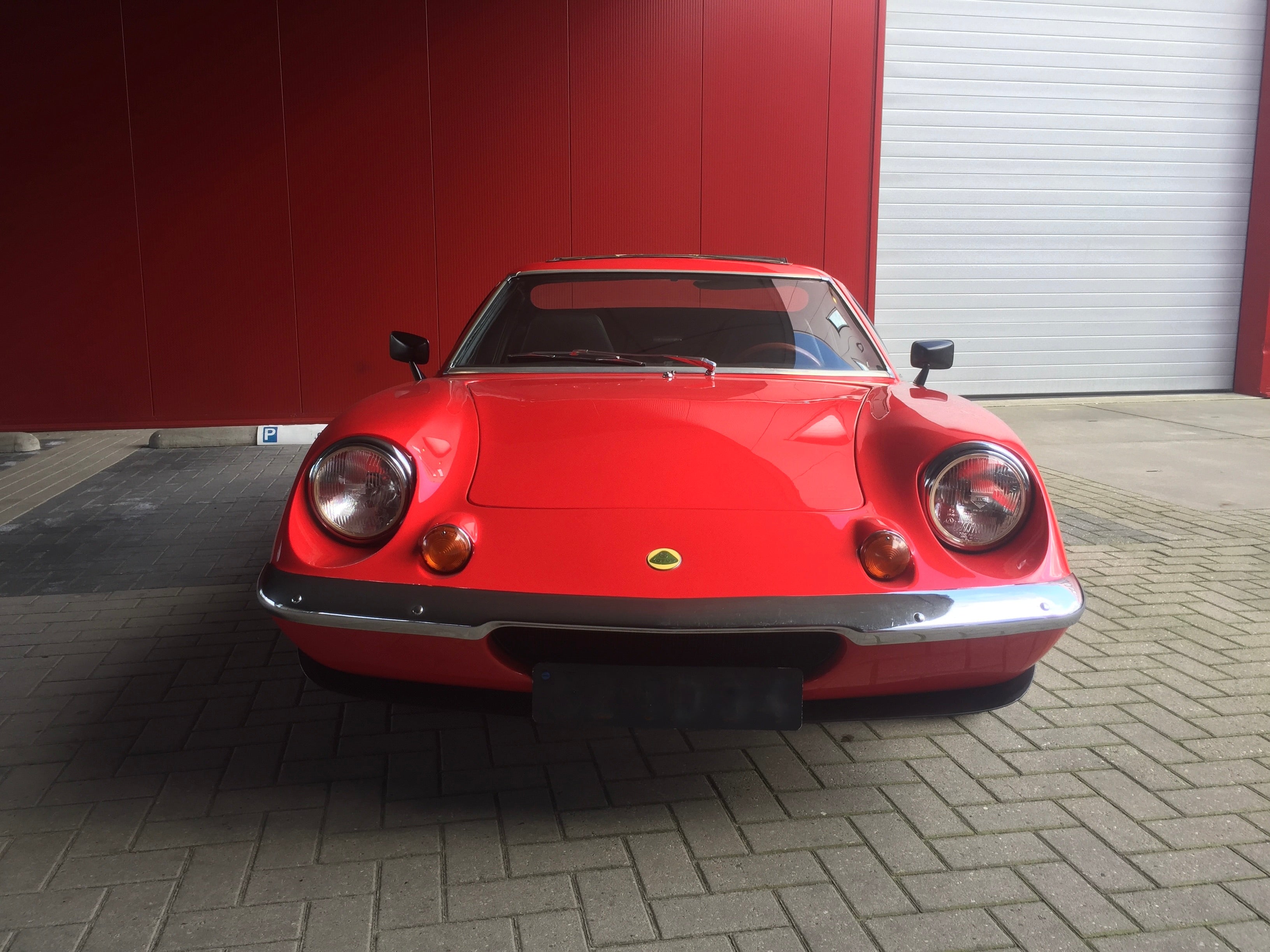 Voiture Lotus Europa Special TC 1974, modèle classique en rouge, vue de côté avec détails de carrosserie et roues.