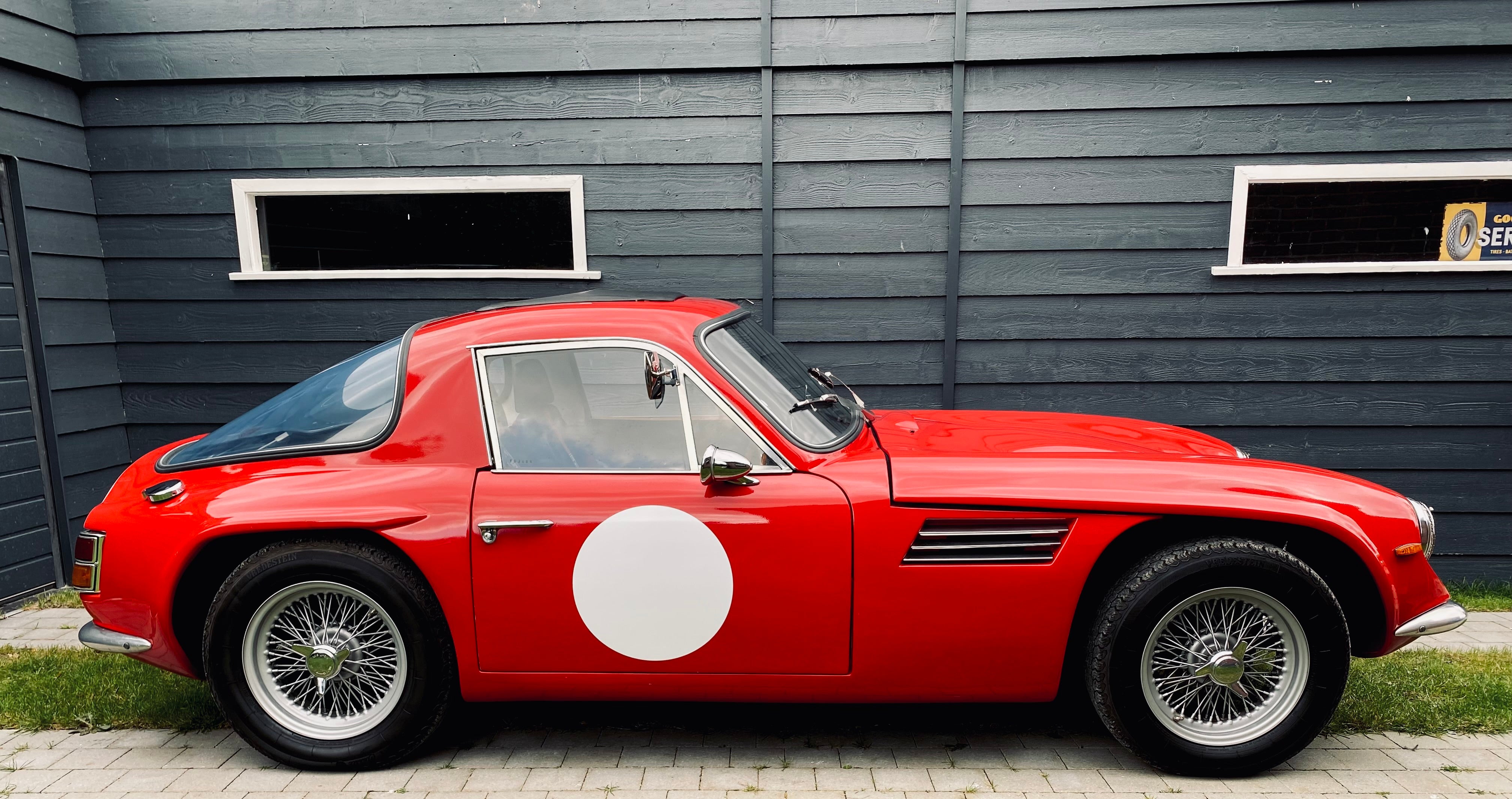 Voiture classique TVR Vixen S2 de 1969, vue de profil, avec carrosserie en rouge et détails vintage.