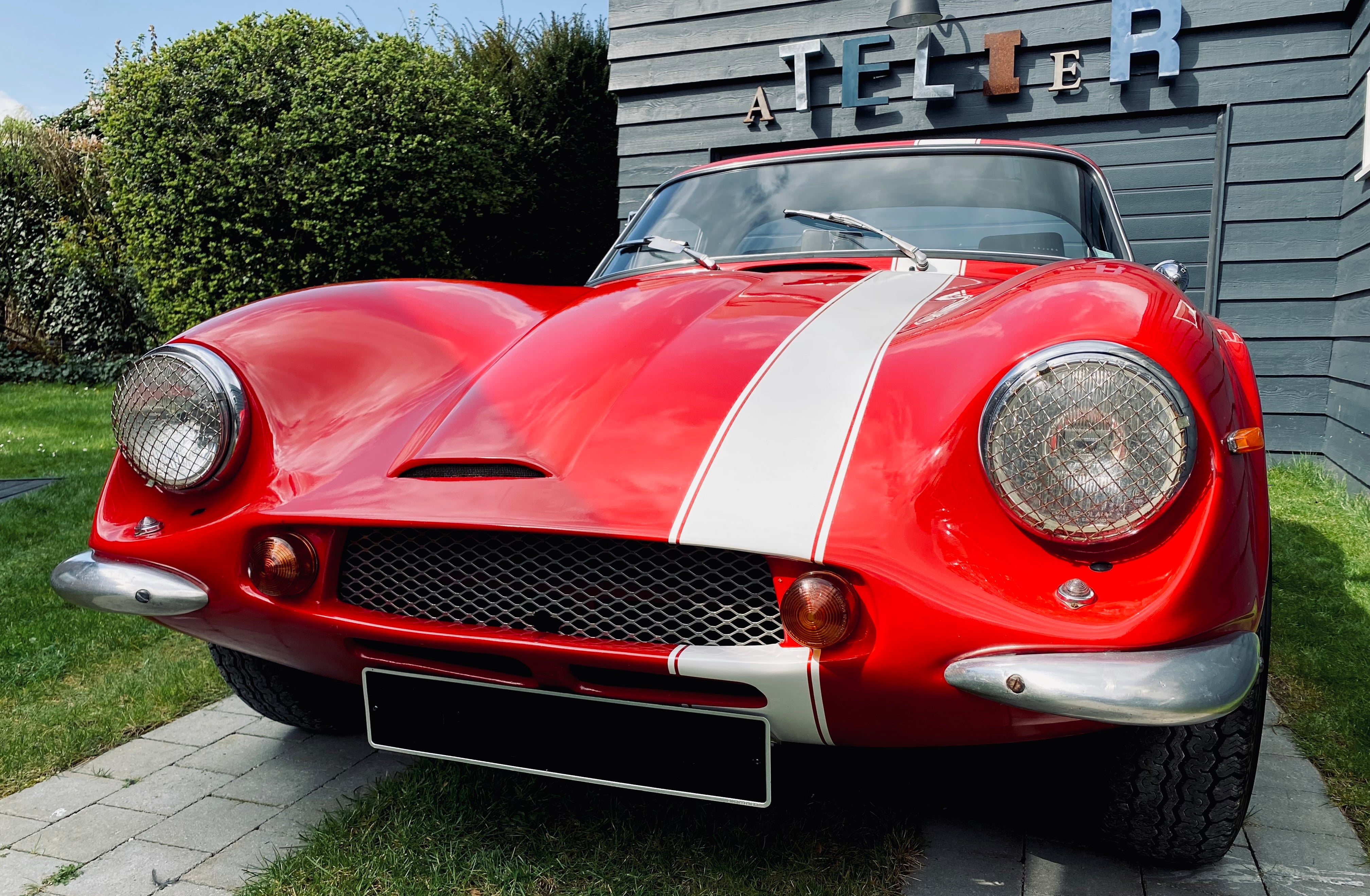 Voiture classique TVR Vixen S2 de 1969 de couleur rouge, vue de face sur une route, en extérieur.