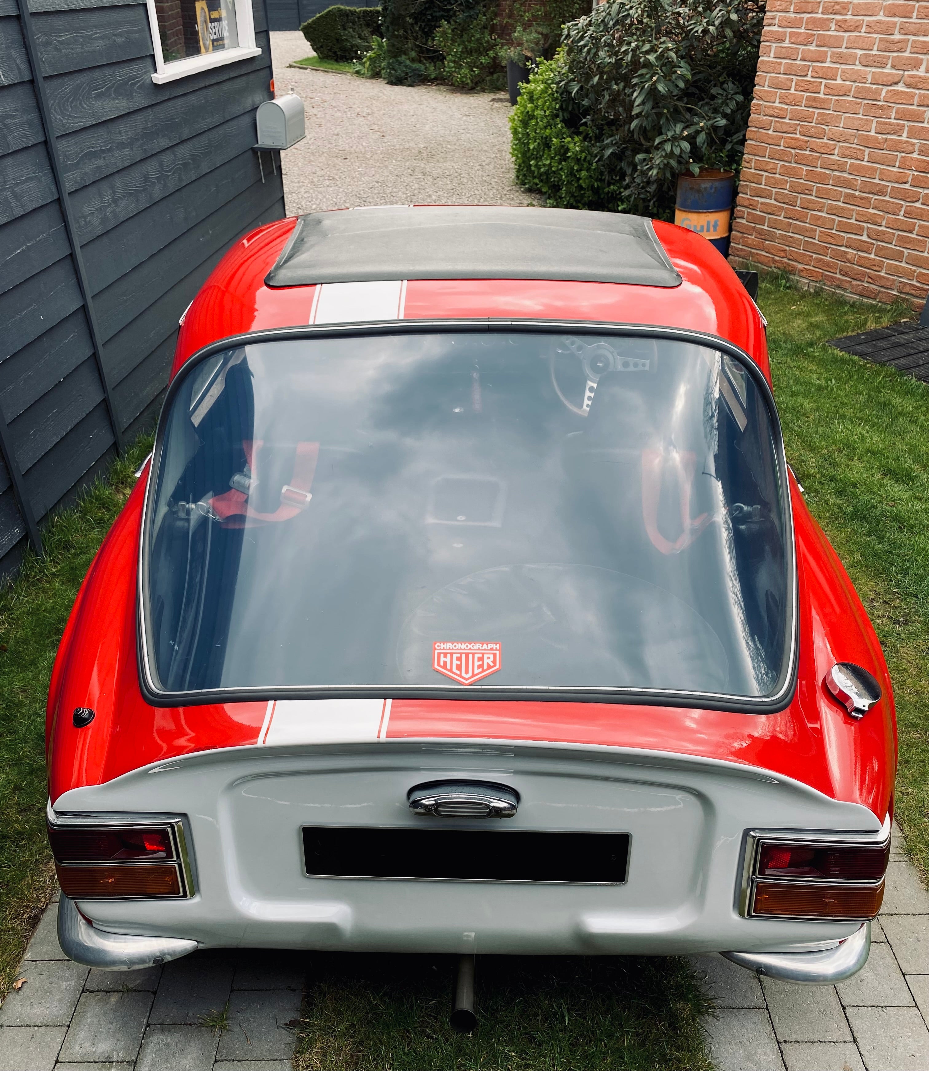 Voiture classique TVR Vixen S2 de 1969 de couleur rouge, vue de face sous un éclairage naturel.