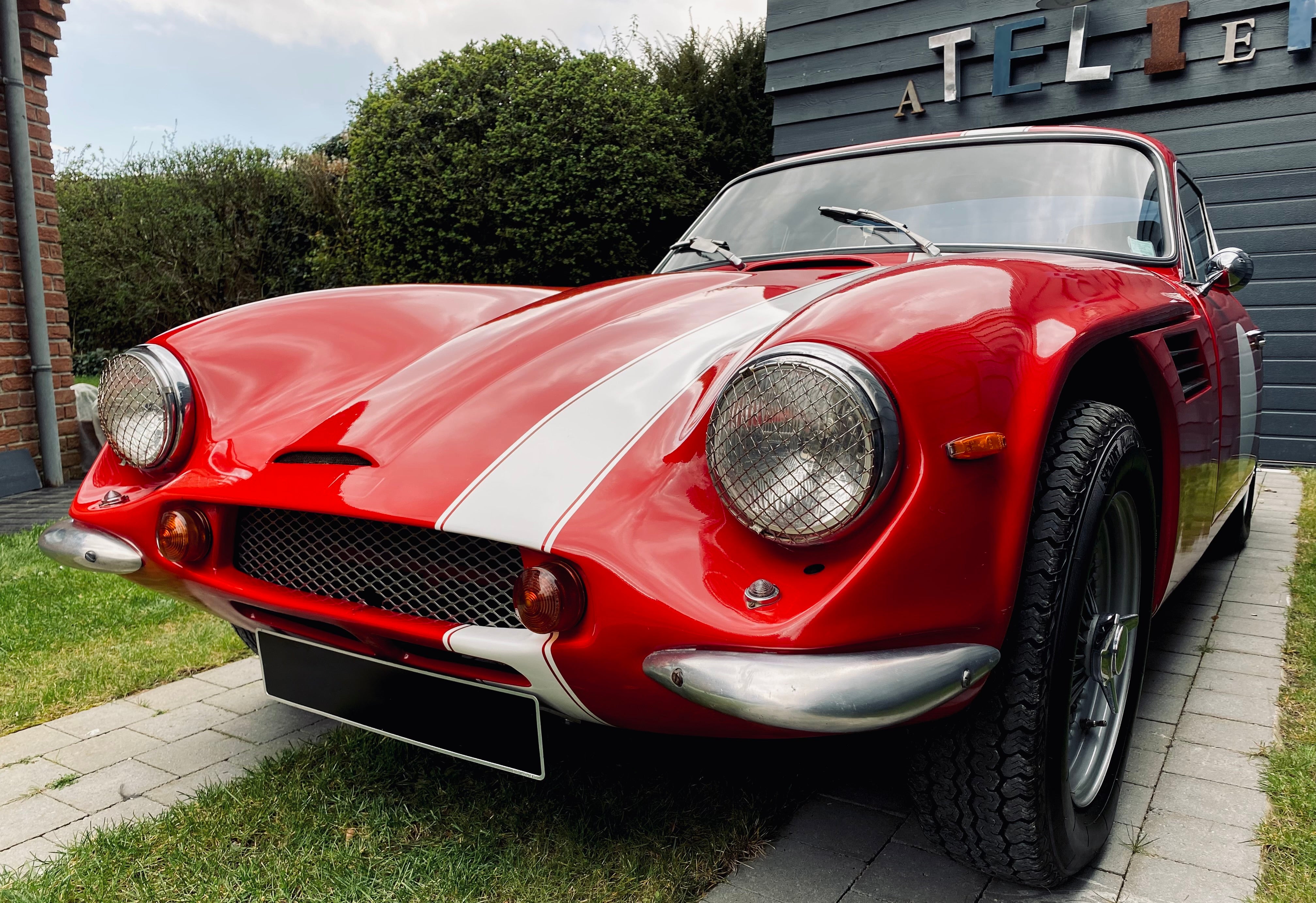 Voiture classique TVR Vixen S2 de 1969 en rouge, vue de face, avec détails du design vintage et intérieur visible