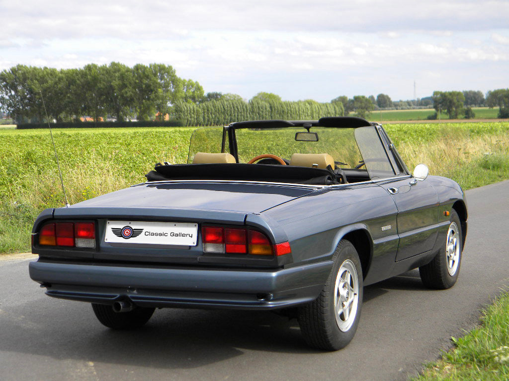 Voiture Alfa Romeo Spider 2.0 Injection essence 1989 avec 137 000 km, vue de côté sur fond neutre.