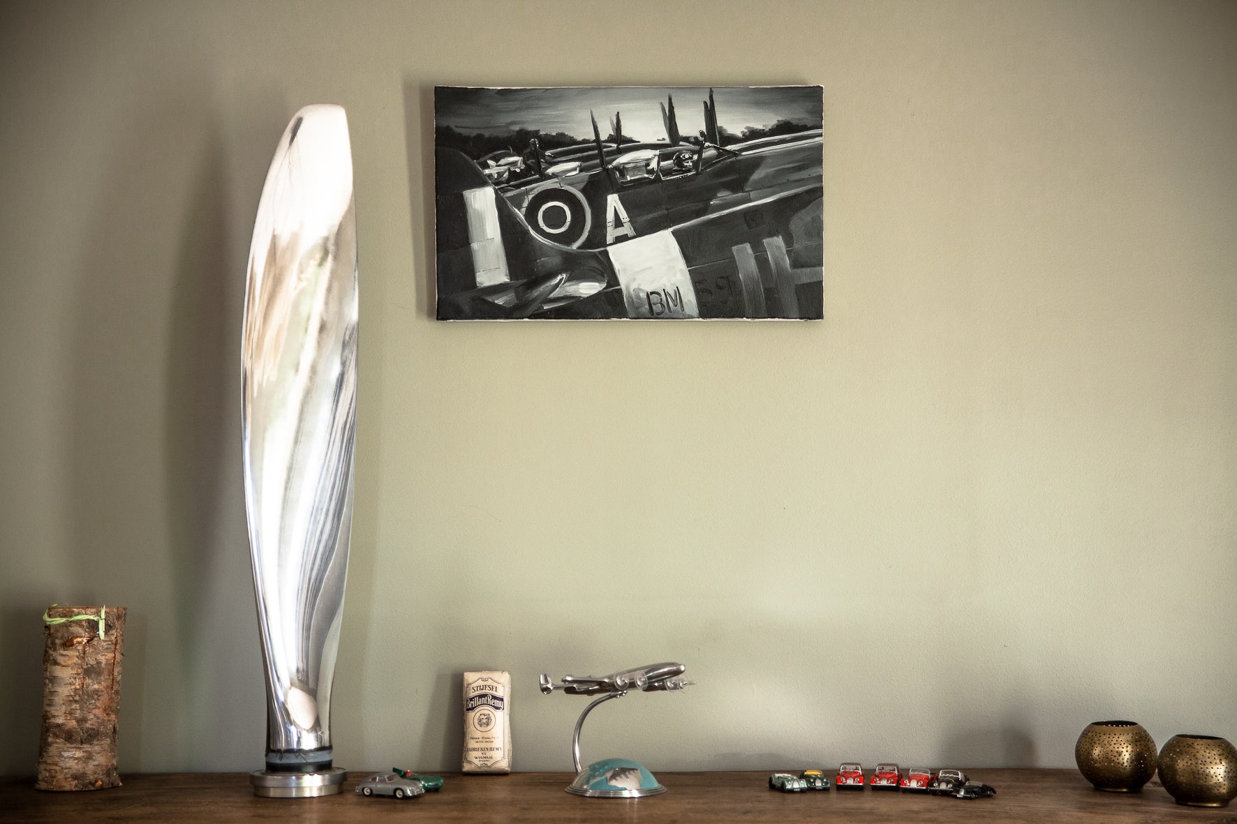 Hélice d’avion de voltige des années 1960, modèle vintage, en bois avec détails métalliques, exposée sur fond neutre