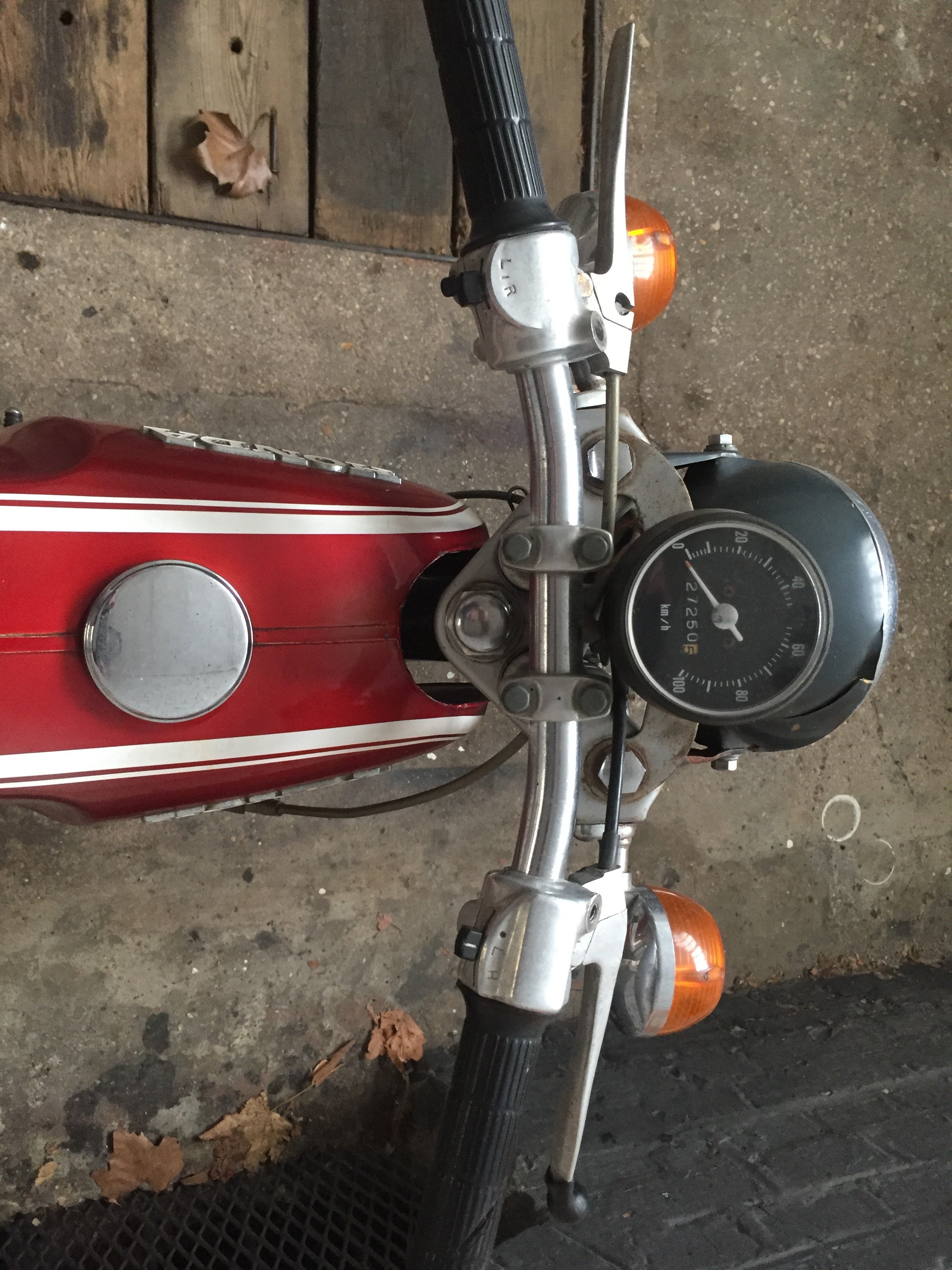 Moto Honda SS 50 cm3 année 1970, vue de côté, avec moteur et cadre vintage, sur fond neutre.