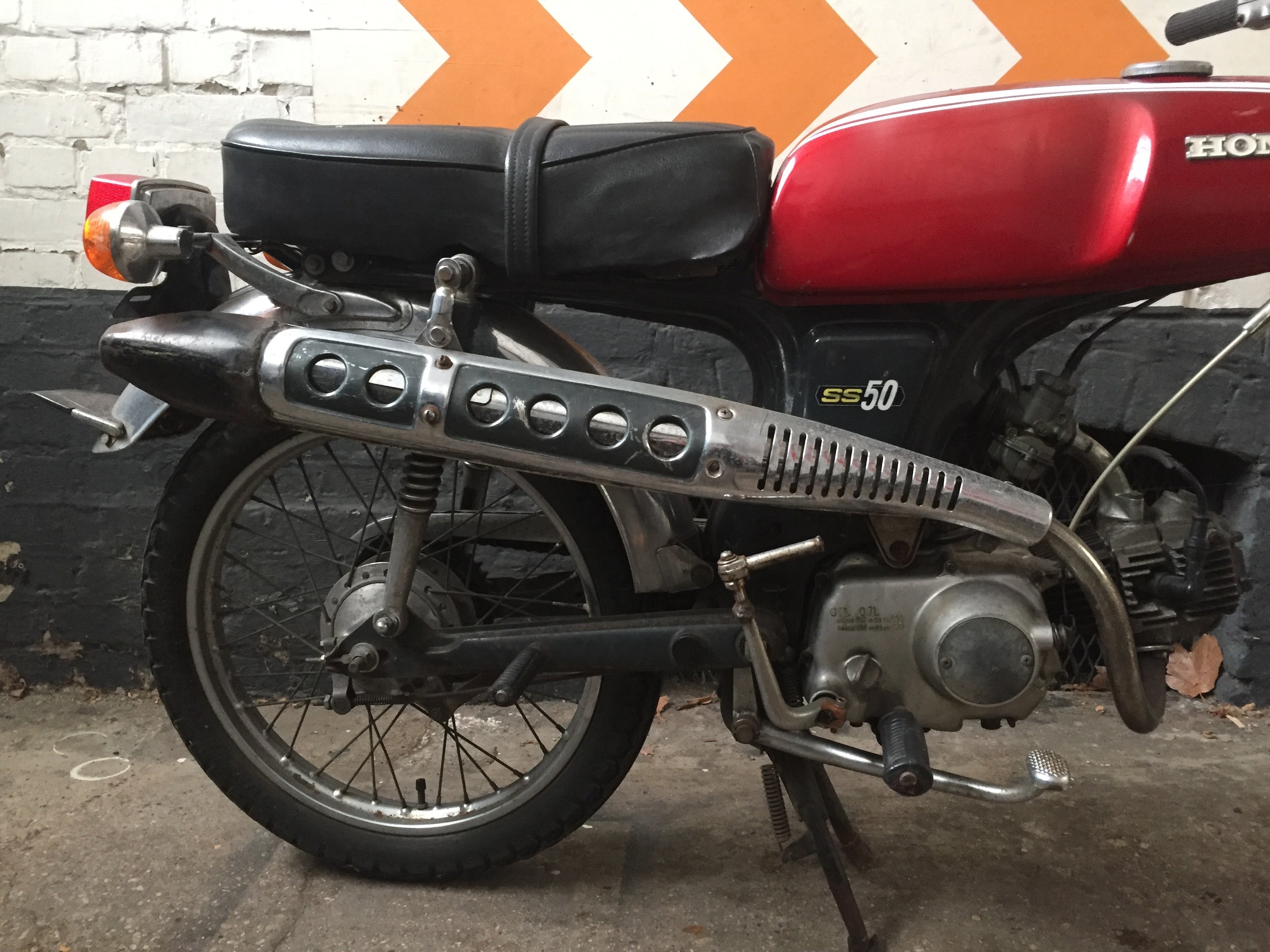 Moto Honda SS 50 cm3 de 1970, vintage, avec détails authentiques, visible en gros plan sur une photo claire.