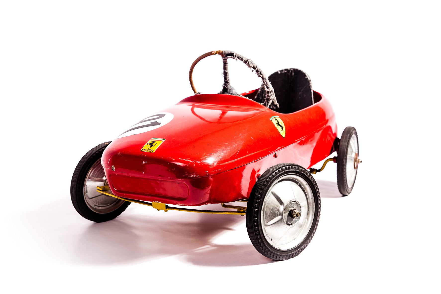 Voiture de course Ferrari à pédale vintage des années 1950, modèle classique en rouge avec détails authentiques.