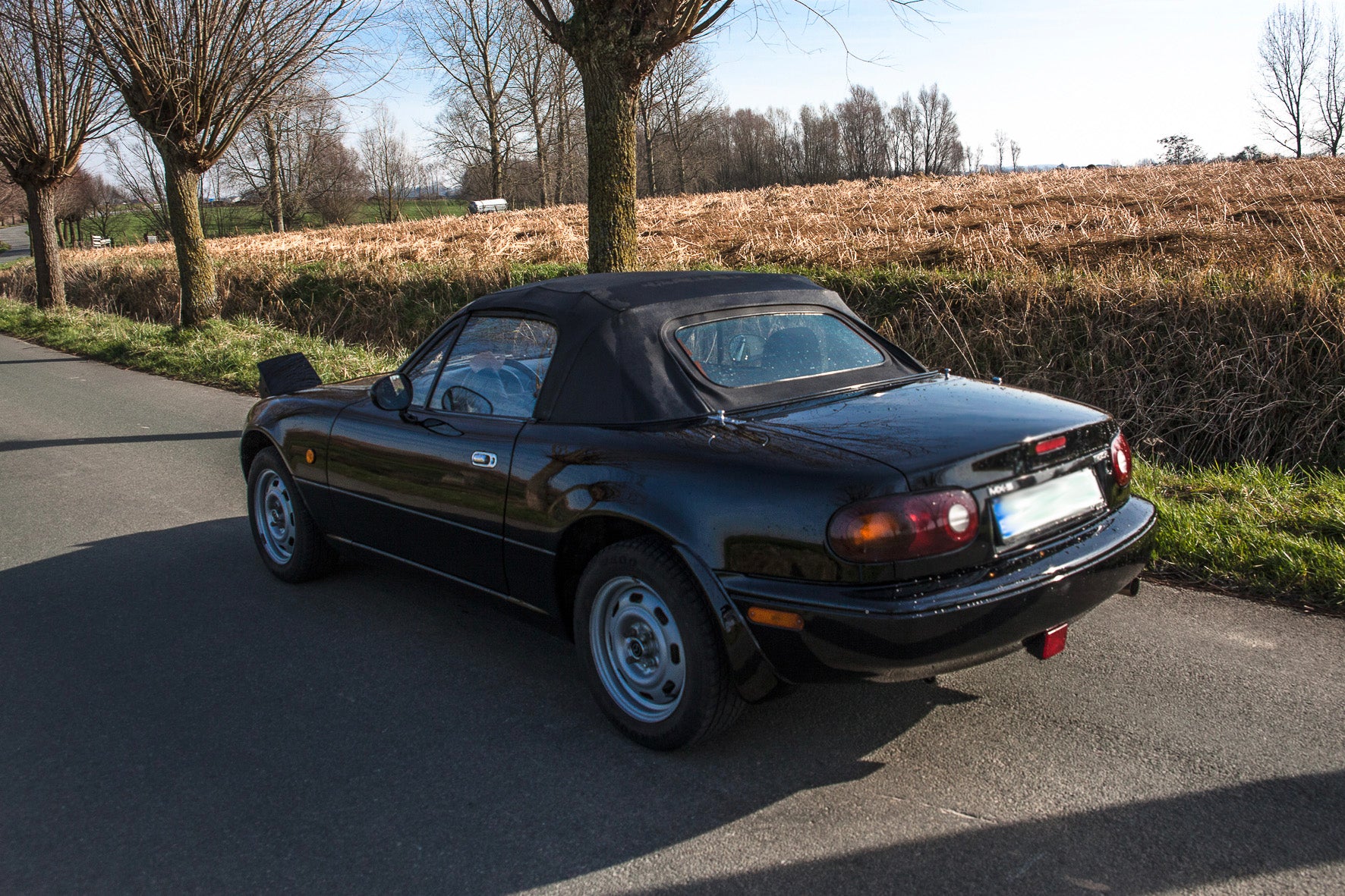 Voiture Mazda MX5 NA 1.6 essence de 1998 avec 105 000 km, vue de face dans un environnement urbain.