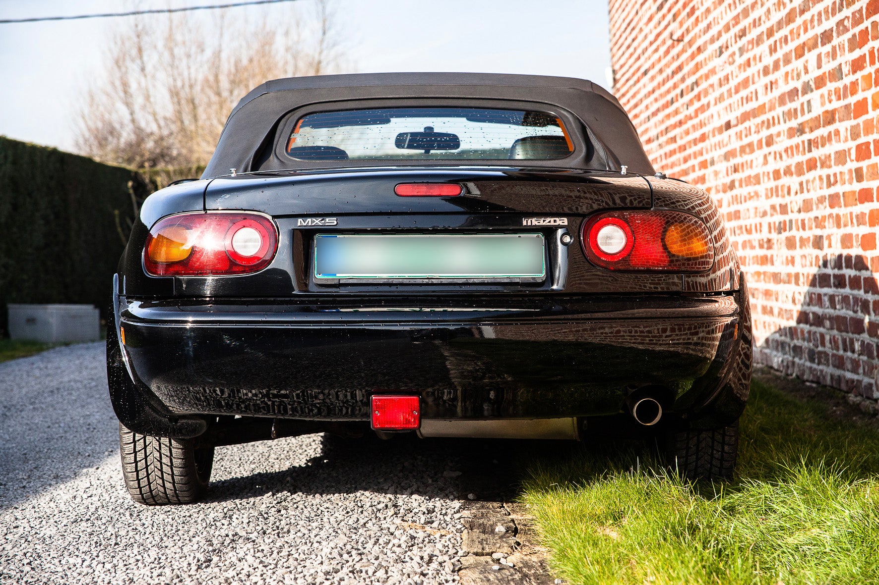 Voiture Mazda MX5 NA 1.6 essence 1998 avec 105 000 km visible, vue de côté sur fond neutre.