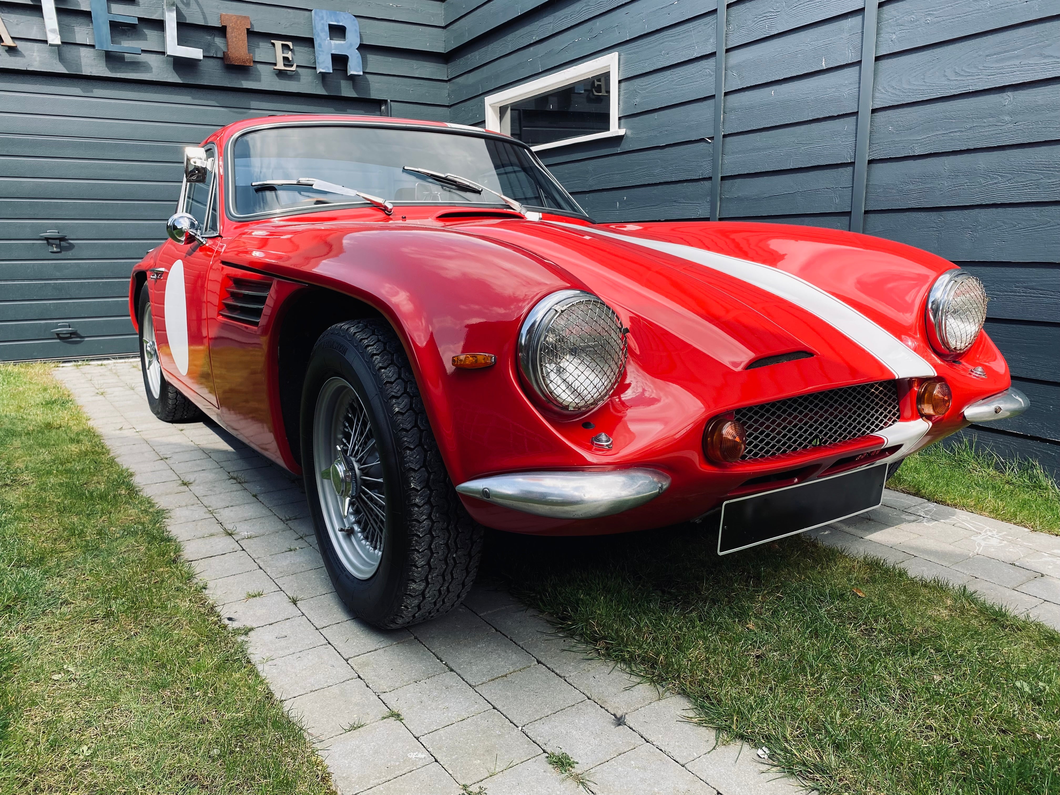 Voiture classique TVR Vixen S2 de 1969 en rouge, vue de côté, avec détails de la carrosserie et des roues.