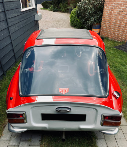 Voiture classique TVR Vixen S2 de 1969 de couleur rouge, vue de face sous un éclairage naturel.