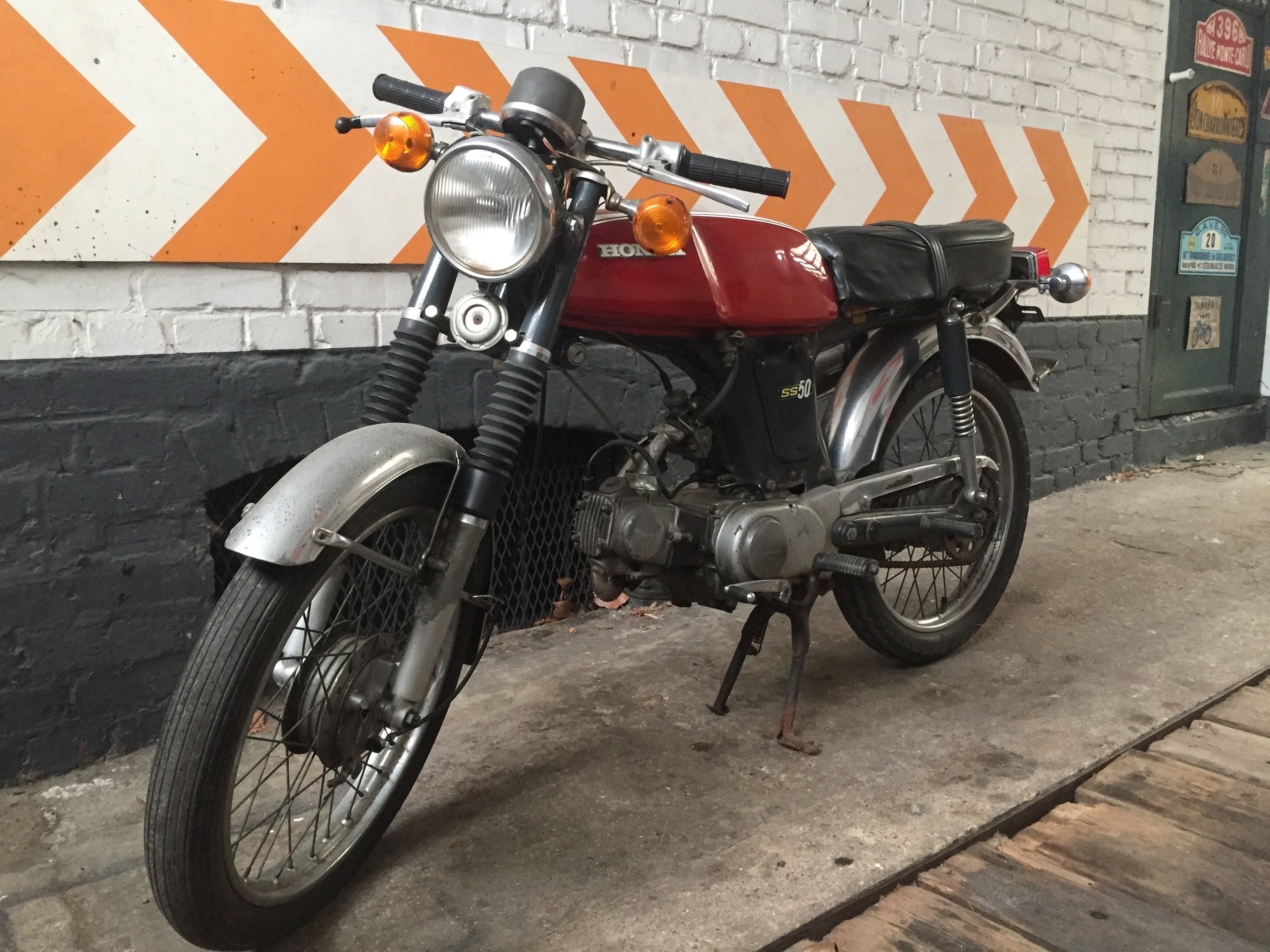 Moto Honda SS 50 cm3 année 1970, vue de côté, avec finition vintage, moteur et détails authentiques visibles.