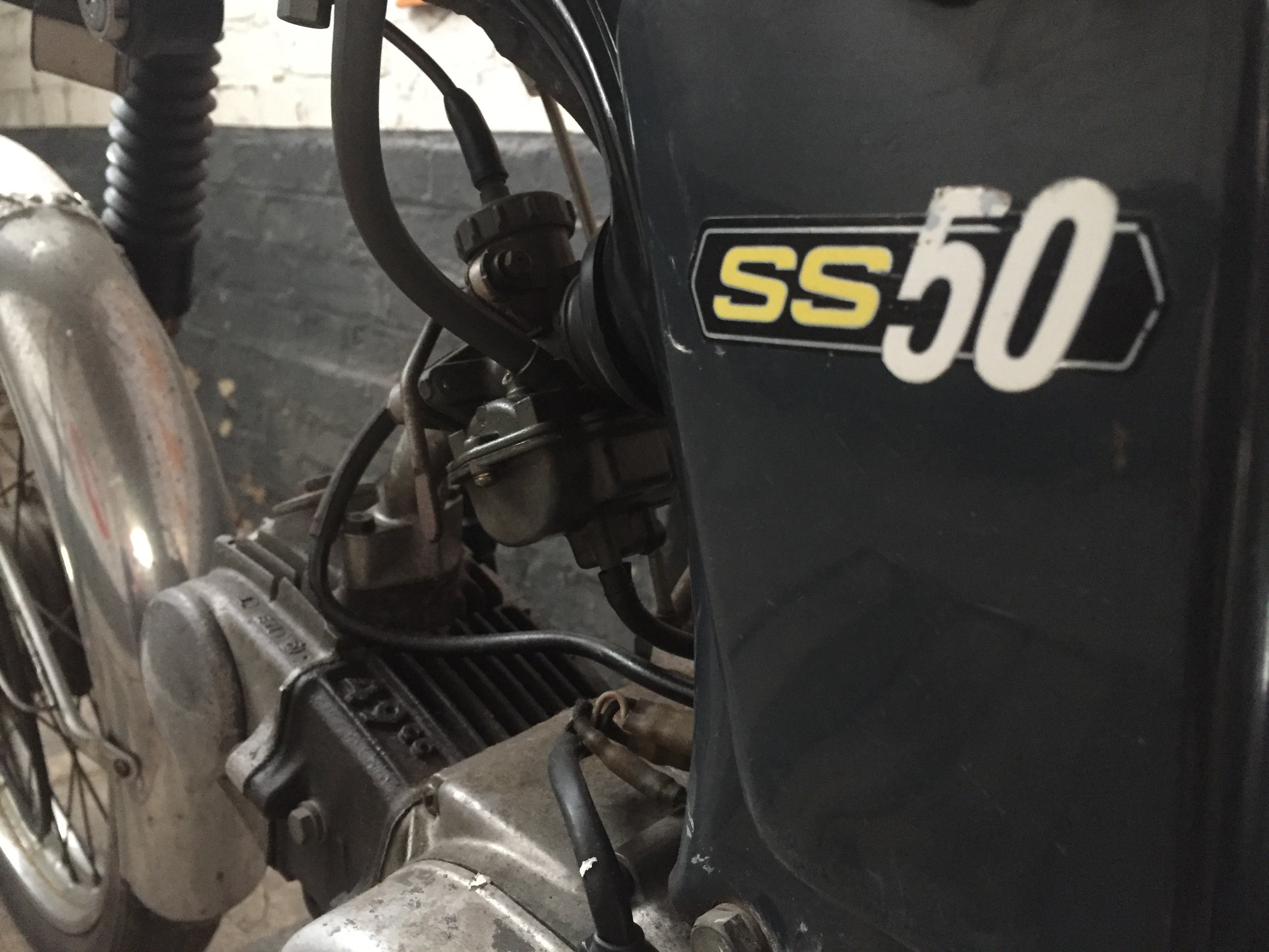 Moto Honda SS 50 cm3 année 1970, vue de côté, avec détails de la carrosserie et du moteur, modèle vintage authentique.