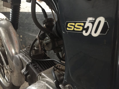 Moto Honda SS 50 cm3 année 1970, vue de côté, avec détails de la carrosserie et du moteur, modèle vintage authentique.