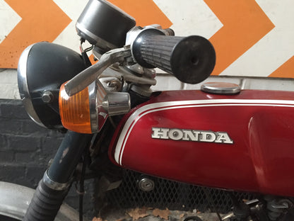 Moto Honda SS 50 cm3 année 1970, vintage, avec guidon, selle et moteur visibles, modèle authentique de cette époque.