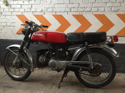 Moto Honda SS 50 cm3 année 1970, vue de côté, avec détails de la carrosserie et du moteur, vintage et authentique.