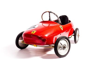 Voiture de course Ferrari à pédale vintage des années 1950, modèle classique en rouge avec détails authentiques.