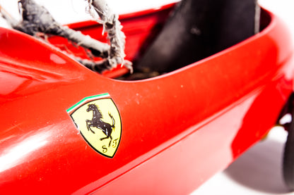Voiture Ferrari de course à pédale vintage des années 1950, modèle classique en rouge avec détails authentiques.