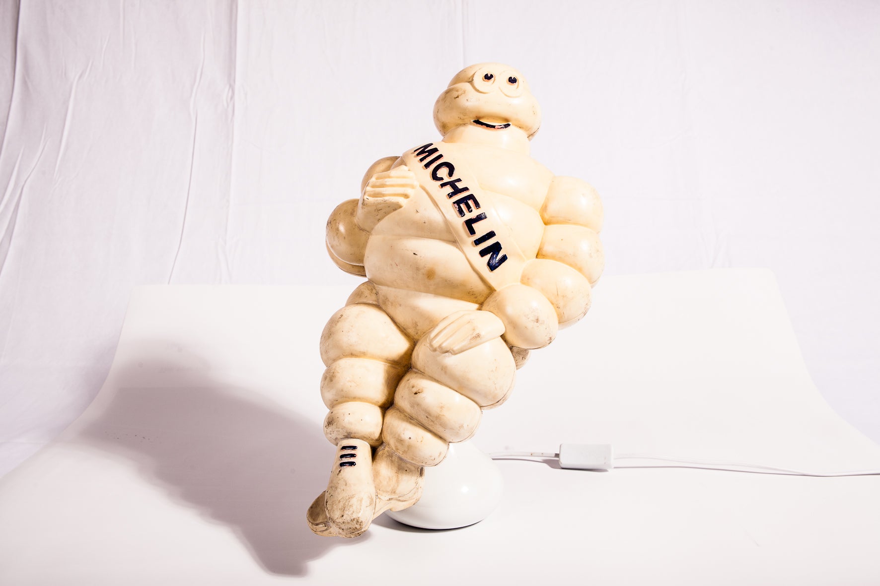 Mascotte Bibendum Michelin de camion vintage des années 1950, célèbre symbole publicitaire, en caoutchouc ou en matériau léger.