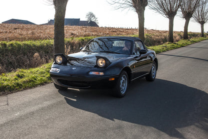 Voiture Mazda MX5 NA 1.6 essence de 1998 avec 105 000 km, vue de face dans un environnement clair.