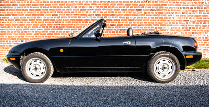 Voiture Mazda MX5 NA 1.6 essence de 1998, 105 000 km, vue de côté avec capot et roues visibles.