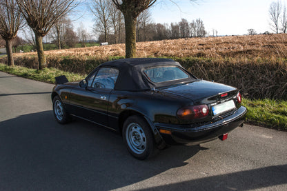 Voiture Mazda MX5 NA 1.6 essence de 1998 avec 105 000 km, vue de face dans un environnement urbain.
