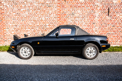 Voiture Mazda MX5 NA 1.6 essence de 1998 avec 105 000 km, vue de face, en bon état, dans un environnement neutre.