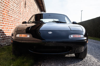 Voiture Mazda MX5 NA 1.6 essence de 1998 avec 105 000 km, vue du côté avec capot fermé.