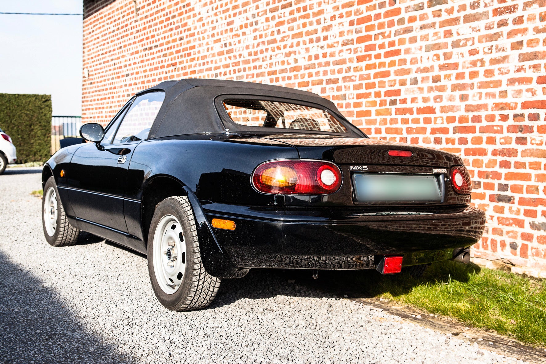 Voiture Mazda MX5 NA 1.6 essence de 1998 avec 105 000 km, vue de face dans un environnement automobile.