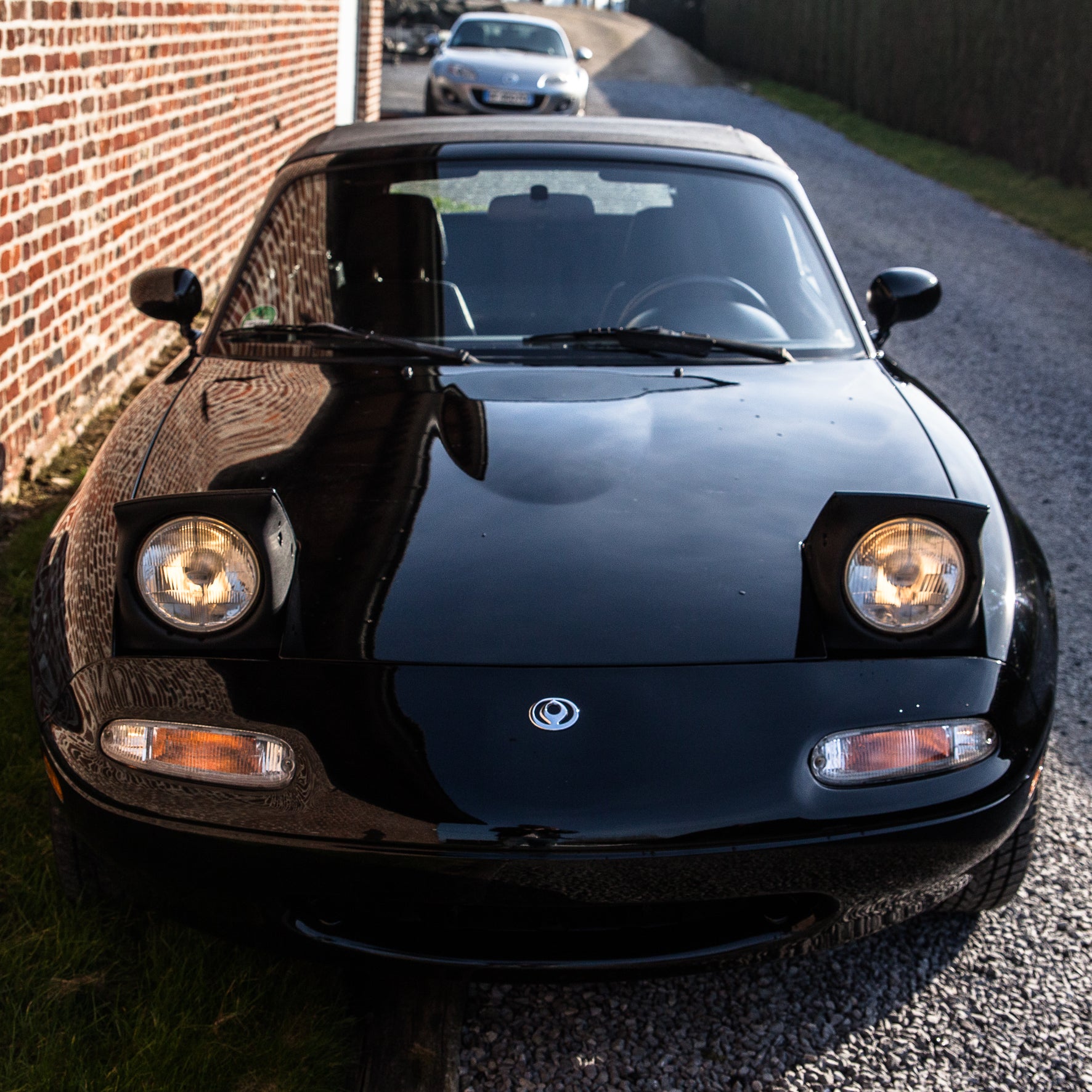 Voiture Mazda MX5 NA 1.6 essence de 1998 avec 105 000 km, vue de face dans un environnement naturel.