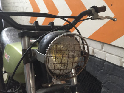 Moto Guzzi 50 Cross de 1970, moto vintage avec cadre rouge, pneus tout-terrain et guidon classique, vue de côté.